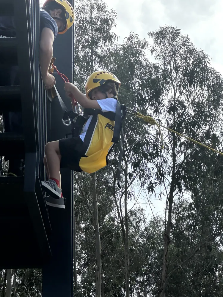 Descida em rapel numa parede, com arnês e capacete